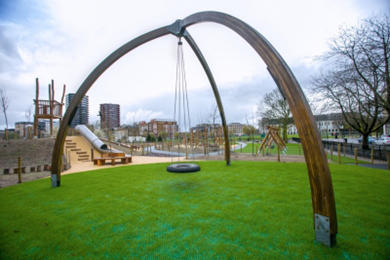 A large rubber tyre swing within a grassy play area